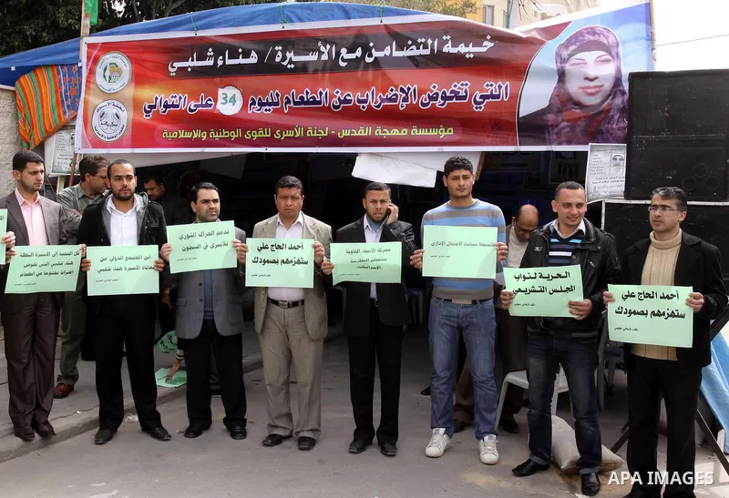 Palestinian employees of the information government office demonstrate in solidarity with Hana'a Shalabi, a female Palestinian prisoner jailed in Israel who has been on hunger strike for 34 days, outside the Red Cross bu...