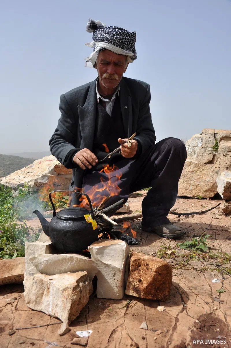 Palestinian shepherd Abu Jaafar makes a tea by a fire in Biet Leed village near the West Bank city of Tulkarem, 20 March 2012. Photo by Nedal Eshtayah