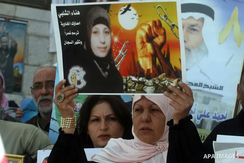 Palestinian women hold portraits of Islamic Jihad supporter Hana Shalabi, a female Palestinian prisoner jailed in Israel who has been on hunger strike for 35 days, during a rally in solidarity with Palestinian prisoners...