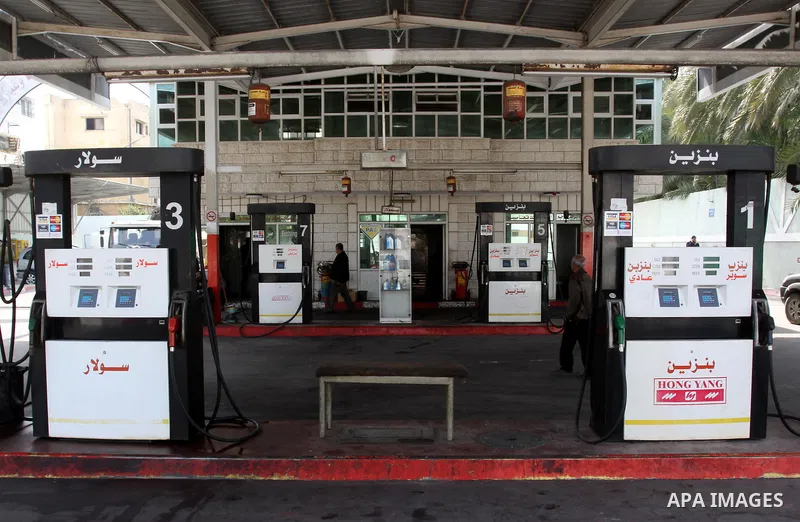 Palestinians fill containers with fuel from a petrol station in the Gaza City on 21 March 2012. Reports state that residents in the Gaza Strip flocked to petrol stations hoping to get a share of the remaining fuel, sayin...