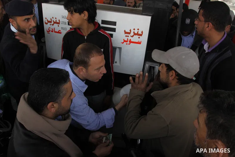 Palestinians fill containers with fuel from a petrol station in the Gaza City on 21 March 2012. Reports state that residents in the Gaza Strip flocked to petrol stations hoping to get a share of the remaining fuel, sayin...