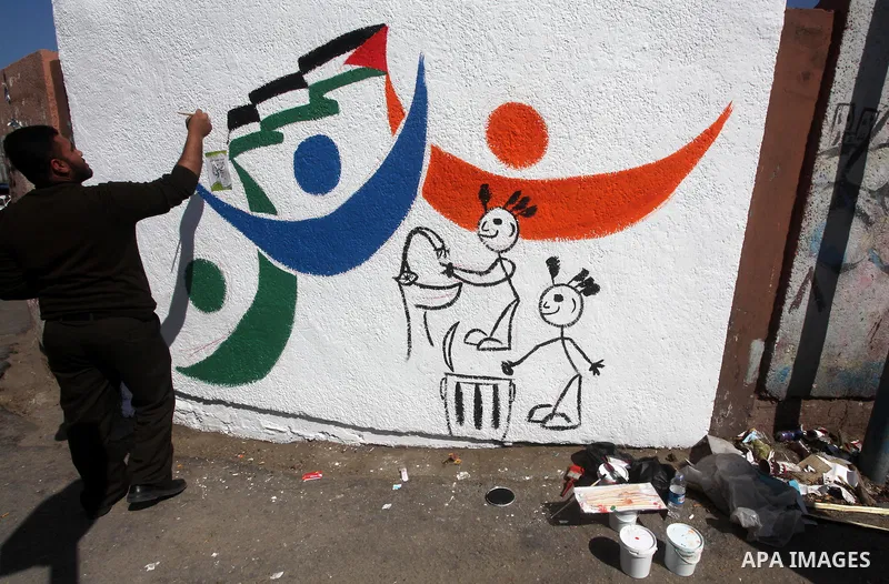 Palestinian artist paints graffiti during the campaign "Cleanliness " in Gaza City on Mar. 22, 2012. Photo by Ashraf Amra