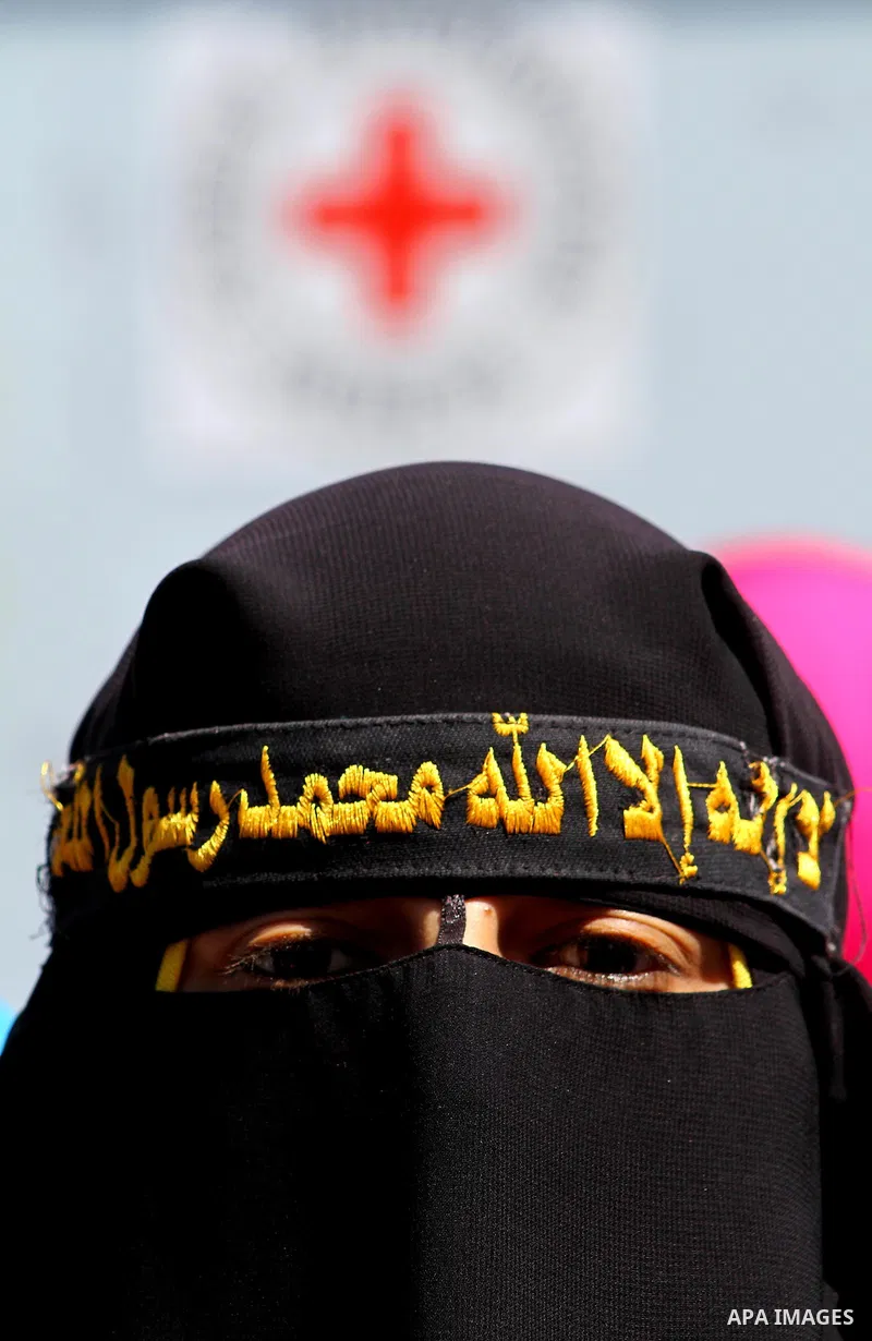 Palestinian women hold portraits of jailed compatriot Hana Shalabi, a female Palestinian prisoner jailed in Israel who has been on hunger strike for 37 days, outside the Red Cross building in Gaza City on Mar. 22, 2012....