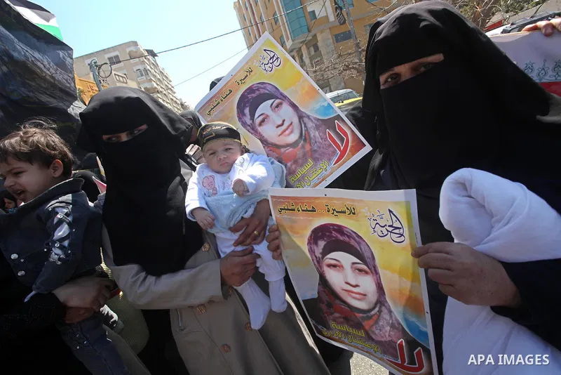 Palestinian women hold portraits of jailed compatriot Hana Shalabi, a female Palestinian prisoner jailed in Israel who has been on hunger strike for 37 days, outside the Red Cross building in Gaza City on Mar. 22, 2012....