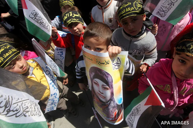 Palestinian children hold portraits of jailed compatriot Hana Shalabi, a female Palestinian prisoner jailed in Israel who has been on hunger strike for 37 days, outside the Red Cross building in Gaza City on Mar. 22, 201...