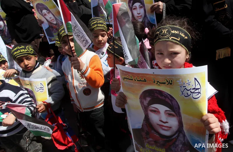 Palestinian children hold portraits of jailed compatriot Hana Shalabi, a female Palestinian prisoner jailed in Israel who has been on hunger strike for 37 days, outside the Red Cross building in Gaza City on Mar. 22, 201...