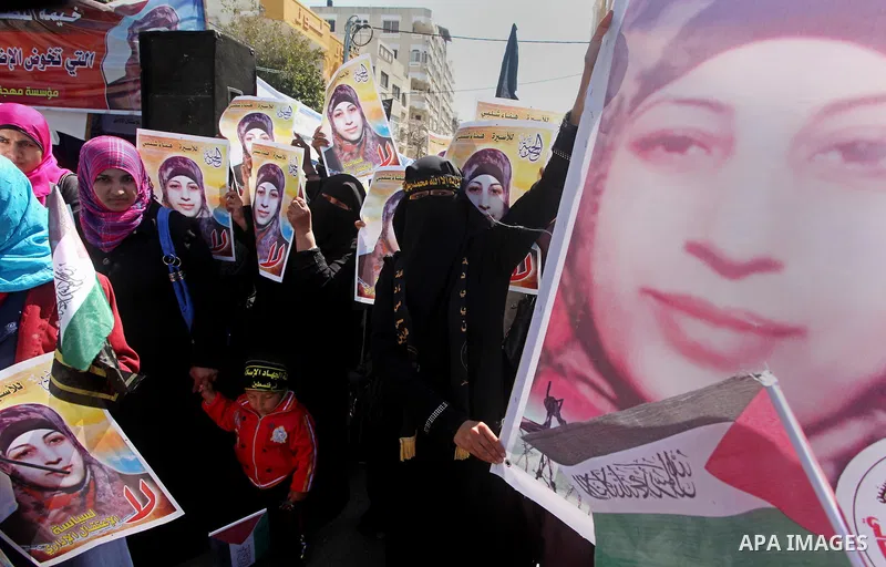 Palestinian women hold portraits of jailed compatriot Hana Shalabi, a female Palestinian prisoner jailed in Israel who has been on hunger strike for 37 days, outside the Red Cross building in Gaza City on Mar. 22, 2012....