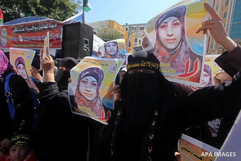 Palestinian women hold portraits of jailed compatriot Hana Shalabi, a female Palestinian prisoner jailed in Israel who has been on hunger strike for 37 days, outside the Red Cross building in Gaza City on Mar. 22, 2012....