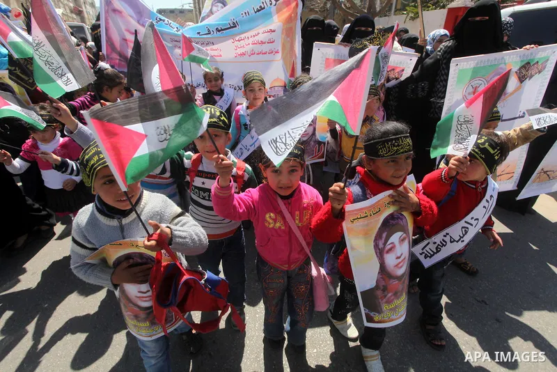 Palestinian children hold portraits of jailed compatriot Hana Shalabi, a female Palestinian prisoner jailed in Israel who has been on hunger strike for 37 days, outside the Red Cross building in Gaza City on Mar. 22, 201...
