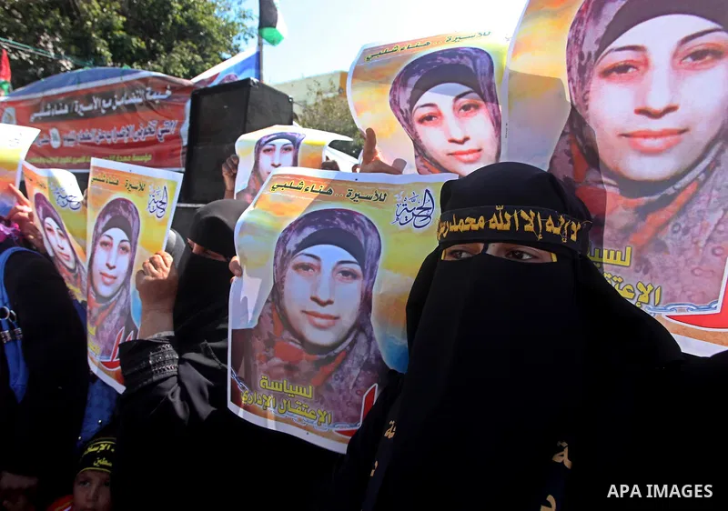 Palestinian women hold portraits of jailed compatriot Hana Shalabi, a female Palestinian prisoner jailed in Israel who has been on hunger strike for 37 days, outside the Red Cross building in Gaza City on Mar. 22, 2012....