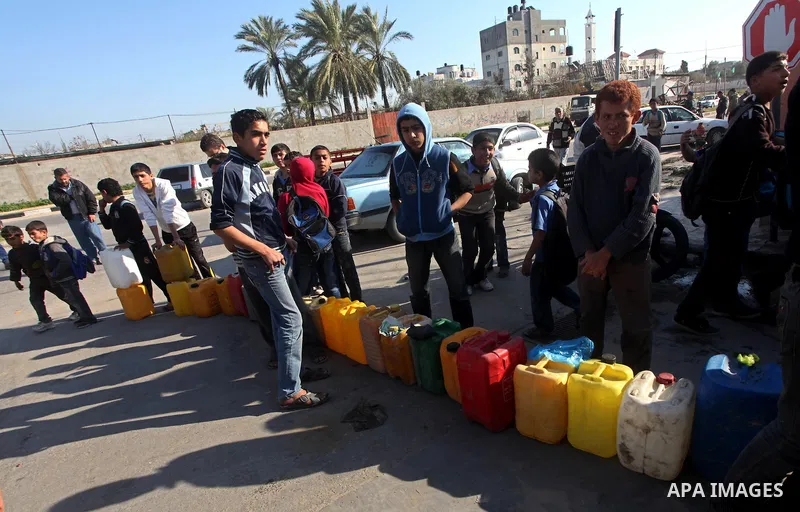 Palestinians wait to fill containers with fuel at a petrol station in Bit Lahia in the northern Gaza Strip March 22, 2012. Palestinians in the Gaza Strip are suffering a crisis of dry petrol pumps and frequent blackouts...