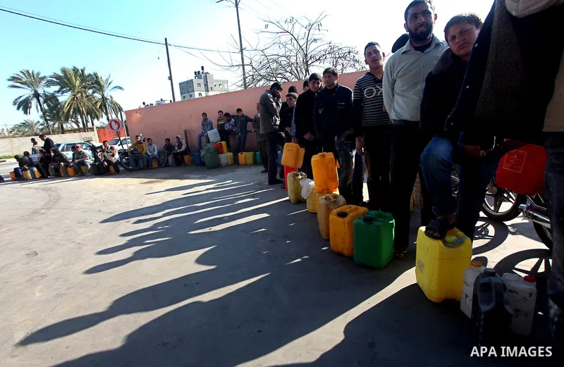 Palestinians wait to fill containers with fuel at a petrol station in Bit Lahia in the northern Gaza Strip March 22, 2012. Palestinians in the Gaza Strip are suffering a crisis of dry petrol pumps and frequent blackouts...