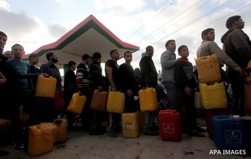 Palestinians wait to fill containers with fuel at a petrol station in Bit Lahia in the northern Gaza Strip March 22, 2012. Palestinians in the Gaza Strip are suffering a crisis of dry petrol pumps and frequent blackouts...