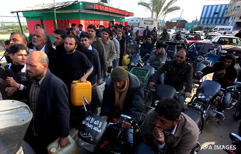 Palestinians wait to fill containers with fuel at a petrol station in Bit Lahia in the northern Gaza Strip March 22, 2012. Palestinians in the Gaza Strip are suffering a crisis of dry petrol pumps and frequent blackouts...