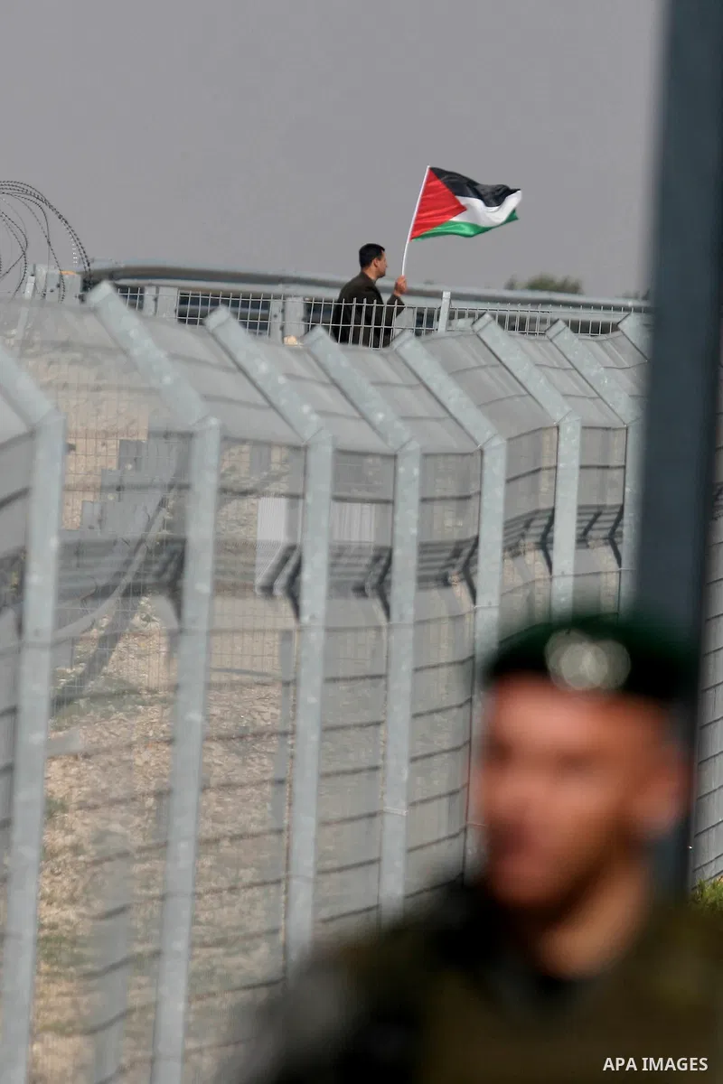Israeli soldiers stand guard in front of Palestinian protesters demonstrating against the relocation of an Israeli road gate in the village of Beit Iksa in the occupied West Bank between Ramallah and Jerusalem on March 2...
