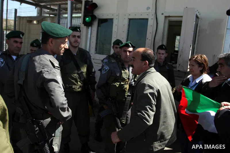 Israeli soldiers stand guard in front of Palestinian protesters demonstrating against the relocation of an Israeli road gate in the village of Beit Iksa in the occupied West Bank between Ramallah and Jerusalem on March 2...