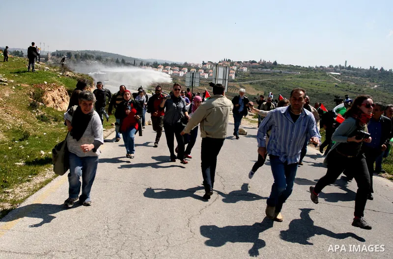 Palestinian protestors run away from tear gas fired by Israeli soldiers during clashes between Israeli soldiers and a group of Palestinian and foreign demonstrators in the West Bank village of Nabi Saleh, near Ramallah o...