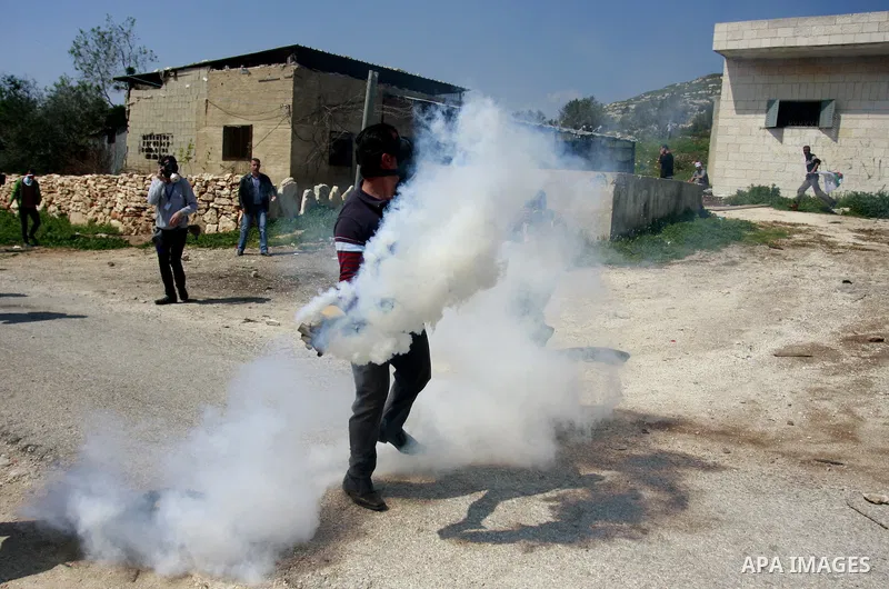 A Palestinian protester throws stones towards Israeli soldiers on March 23, 2012, during a protest against the closure of a road during the second Intifada (began late September 2000) by Jewish settlers from the nearby s...