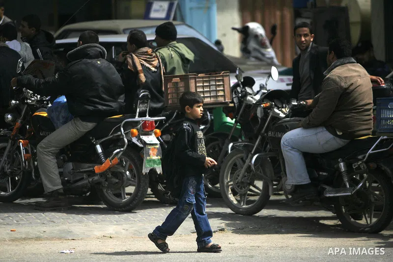 Palestinians wait to fill containers with fuel at a petrol station in Rafah on the southern Gaza Strip March 24, 2012. Palestinians in the Gaza Strip are suffering a crisis of dry petrol pumps and frequent blackouts trig...