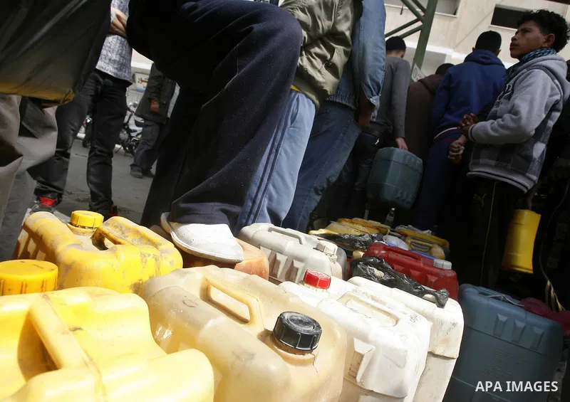 Palestinians wait to fill containers with fuel at a petrol station in Rafah on the southern Gaza Strip March 24, 2012. Palestinians in the Gaza Strip are suffering a crisis of dry petrol pumps and frequent blackouts trig...