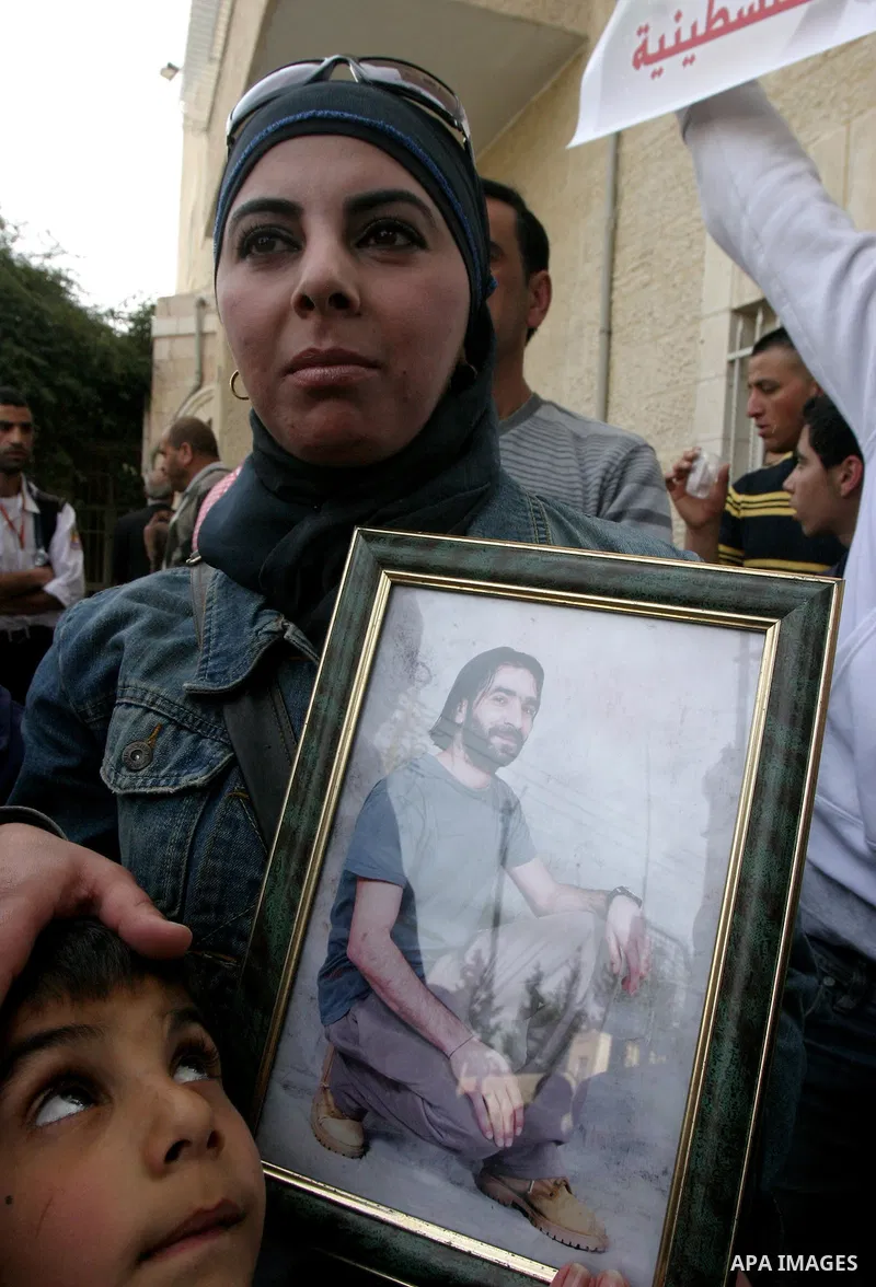 Palestinians hold portraits of relatives detained in Israeli prisons as they protest to demand for their release during a demonstration in support of Hanaa al-Shalabi outside Damascus gate, in the old city of Jerusalem,...