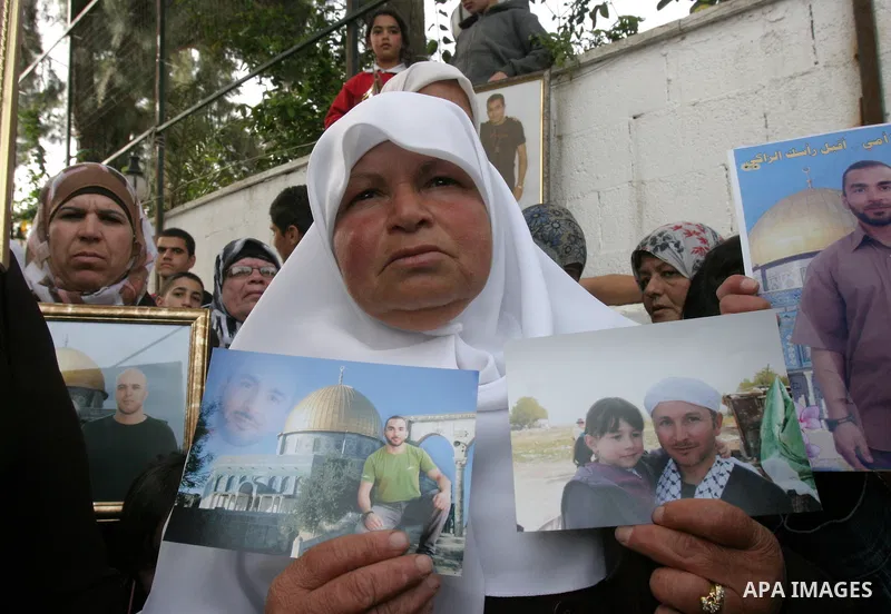 Palestinians hold portraits of relatives detained in Israeli prisons as they protest to demand for their release during a demonstration in support of Hanaa al-Shalabi outside Damascus gate, in the old city of Jerusalem,...