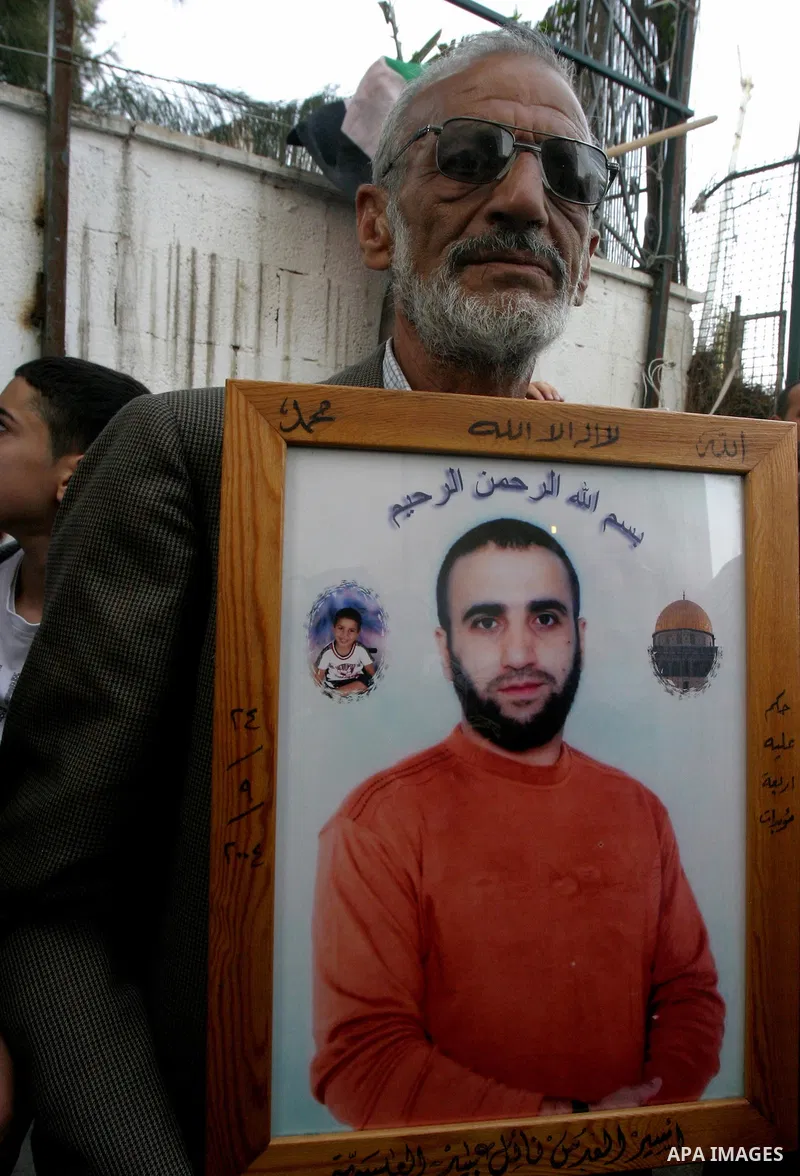 Palestinians hold portraits of relatives detained in Israeli prisons as they protest to demand for their release during a demonstration in support of Hanaa al-Shalabi outside Damascus gate, in the old city of Jerusalem,...