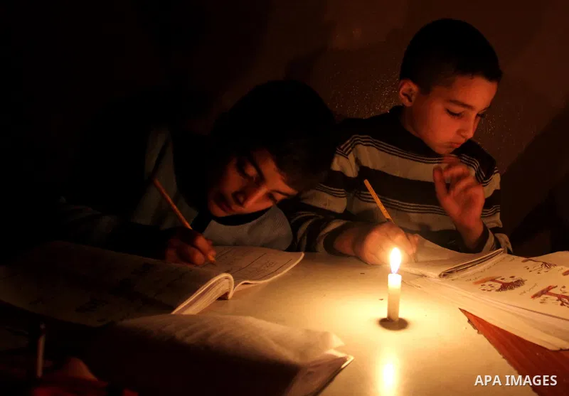 Palestinian children use a candle light during a power cut in Jabaliya refugee camp in the northern Gaza Strip 24 March 2012. The only remaining power plant in the Gaza Strip halted working because it run out of fuel, ca...