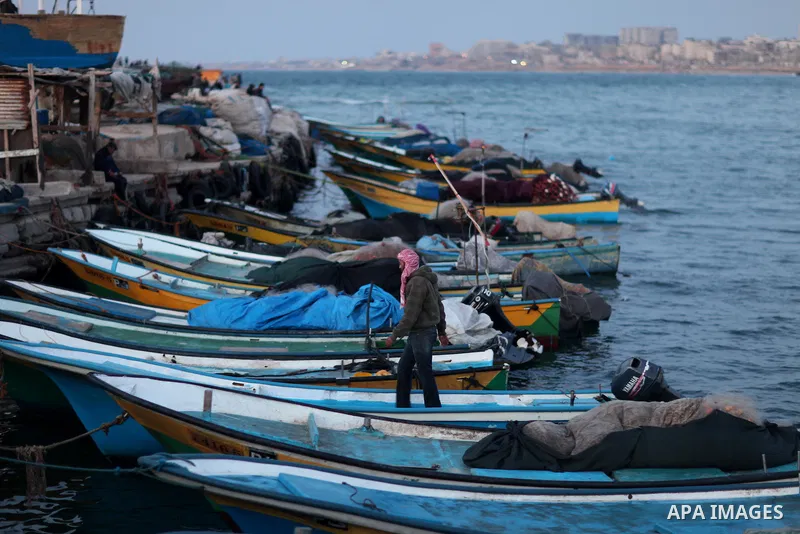 Palestinians enjoy their times during the sunset in Gaza fishing seaport, on March 23, 2012. Photo by Emad Nassar