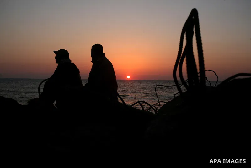 Palestinians enjoy their times during the sunset in Gaza fishing seaport, on March 23, 2012. Photo by Emad Nassar