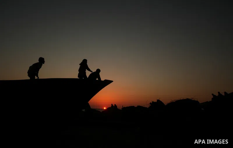 Palestinians enjoy their times during the sunset in Gaza fishing seaport, on March 23, 2012. Photo by Emad Nassar