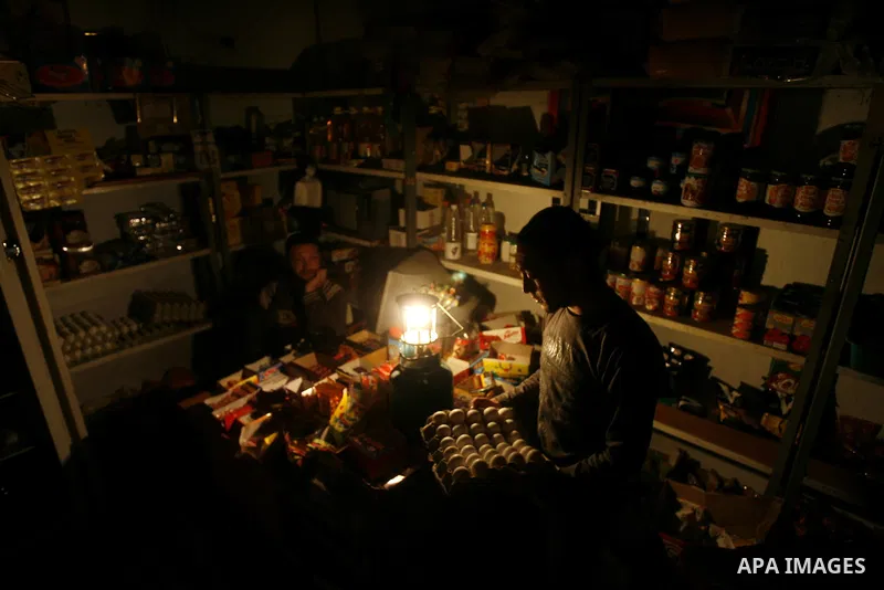 A Palestinian man sits in his shop during a blackout in Rafah on the southern Gaza Strip on, 26 March 2012. The only remaining power plant in the Gaza Strip halted working because it run out of fuel, causing a blackout,...