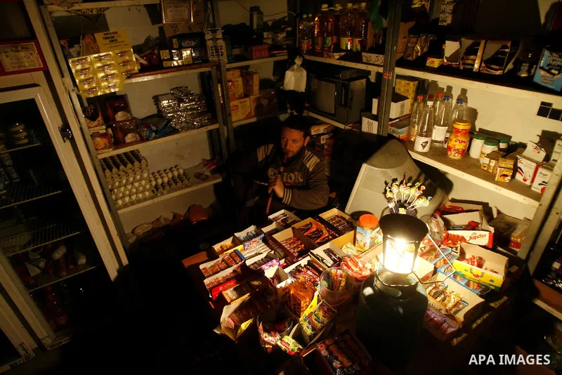 A Palestinian man sits in his shop during a blackout in Rafah on the southern Gaza Strip on, 26 March 2012. The only remaining power plant in the Gaza Strip halted working because it run out of fuel, causing a blackout,...