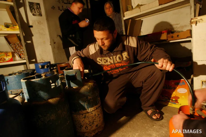 A Palestinian man fills gas cylinders in Rafah on the southern Gaza Strip on, 26 March 2012. Palestinians in the Gaza Strip are suffering a crisis of dry petrol pumps and frequent blackouts triggered by a fuel supply dis...