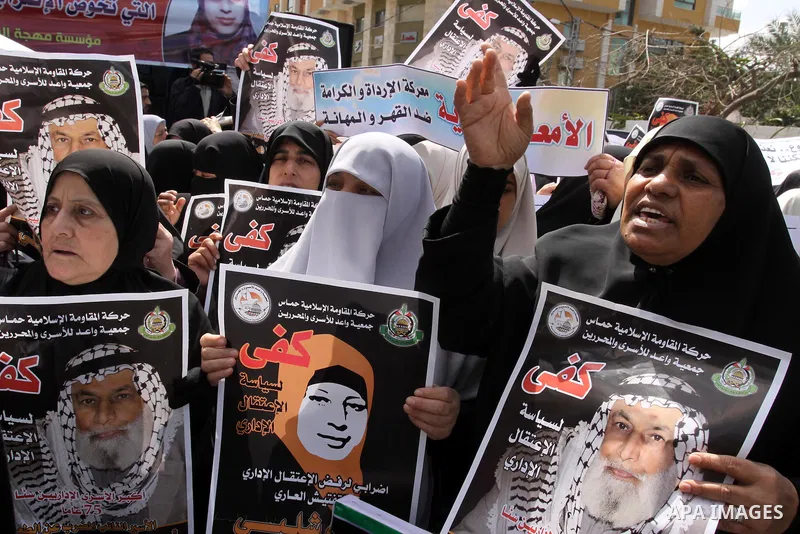Palestinian women hold portrait of jailed compatriot Hana Shalabi, a female Palestinian prisoner jailed in Israel, outside the Red Cross building in Gaza City on March 26, 2012. Photo by Mohammed Asad