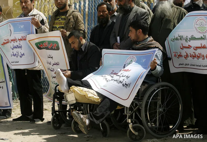 Palestinian demonstrators hold posters during a protest in the Rafah border crossing with Egypt on March 26, 2012, demanding Egypt provide the Gaza Strip with electricity and fuel. The Palestinian energy authority in Gaz...