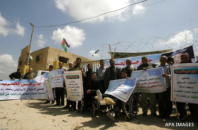 Palestinian demonstrators hold posters during a protest in the Rafah border crossing with Egypt on March 26, 2012, demanding Egypt provide the Gaza Strip with electricity and fuel. The Palestinian energy authority in Gaz...