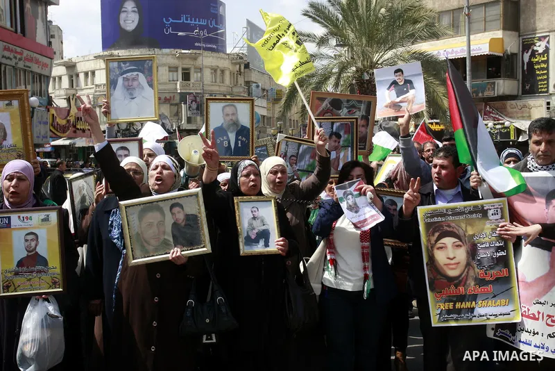 Palestinians hold pictures of prisoners jailed in Israel during a demonstration calling for their release, in the West Bank city of Nablus, Monday, March 26, 2012. Photo by Wagdi Eshtayah