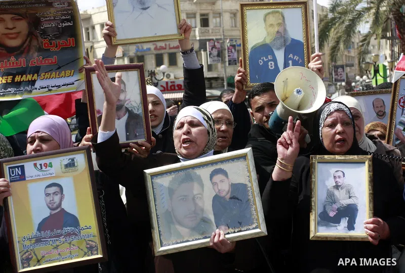 Palestinians hold pictures of prisoners jailed in Israel during a demonstration calling for their release, in the West Bank city of Nablus, Monday, March 26, 2012. Photo by Wagdi Eshtayah