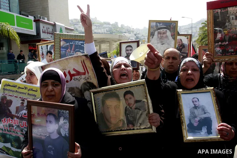 Palestinians hold pictures of prisoners jailed in Israel during a demonstration calling for their release, in the West Bank city of Nablus, Monday, March 26, 2012. Photo by Wagdi Eshtayah