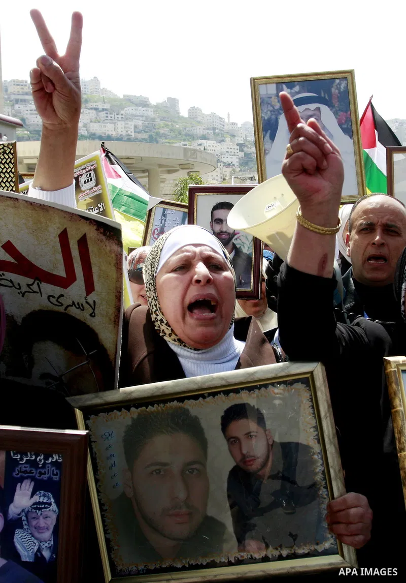 Palestinians hold pictures of prisoners jailed in Israel during a demonstration calling for their release, in the West Bank city of Nablus, Monday, March 26, 2012. Photo by Wagdi Eshtayah
