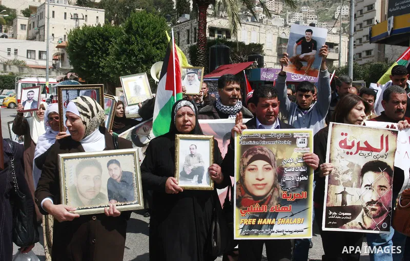 Palestinians hold pictures of prisoners jailed in Israel during a demonstration calling for their release, in the West Bank city of Nablus, Monday, March 26, 2012. Photo by Wagdi Eshtayah