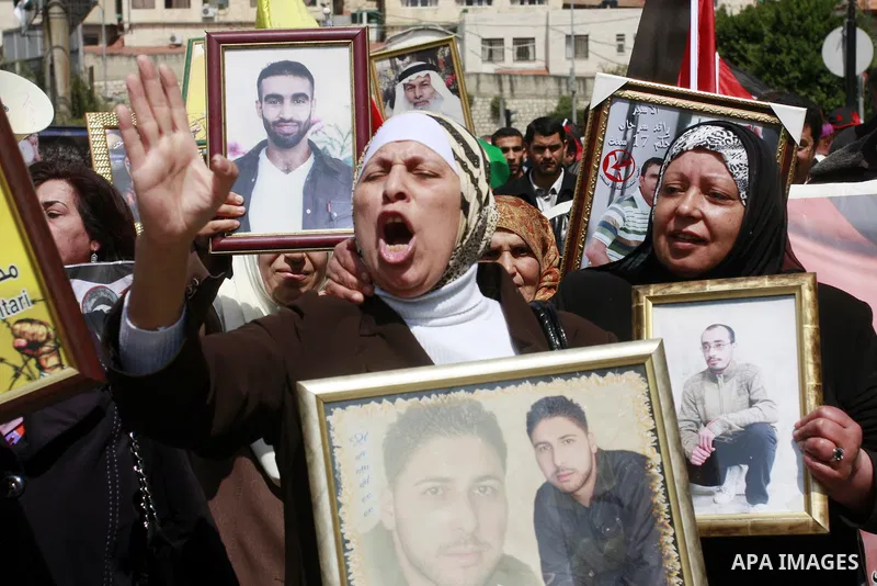 Palestinians hold pictures of prisoners jailed in Israel during a demonstration calling for their release, in the West Bank city of Nablus, Monday, March 26, 2012. Photo by Wagdi Eshtayah