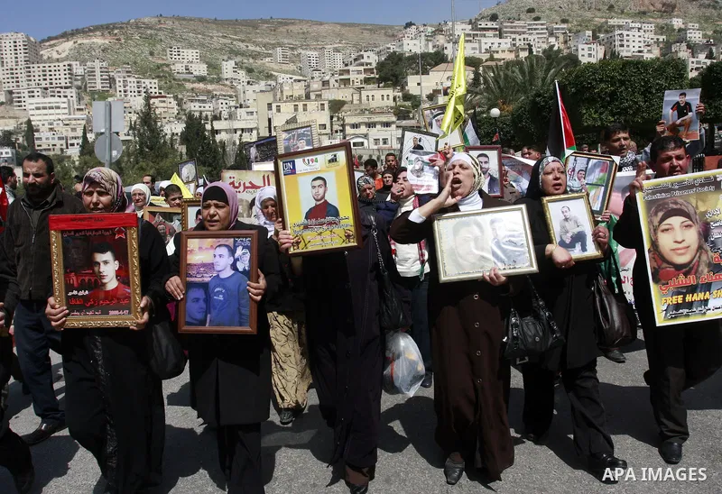 Palestinians hold pictures of prisoners jailed in Israel during a demonstration calling for their release, in the West Bank city of Nablus, Monday, March 26, 2012. Photo by Wagdi Eshtayah