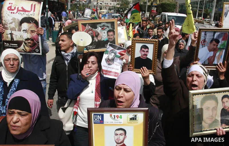 Palestinians hold pictures of prisoners jailed in Israel during a demonstration calling for their release, in the West Bank city of Nablus, Monday, March 26, 2012. Photo by Wagdi Eshtayah