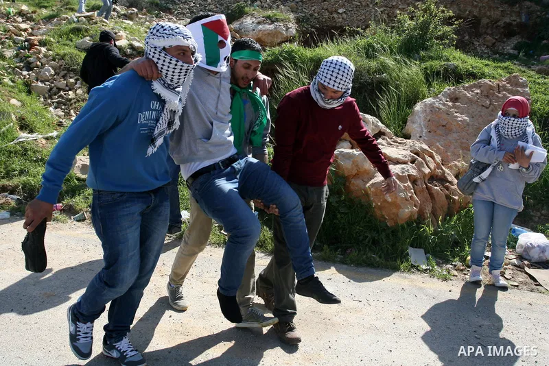 Palestinians clash with Israeli troops, not seen, during a protest outside the Ofer military prison, near the West Bank city of Ramallah Monday, March 26, 2012. Clashes erupted during a demonstration calling to release p...