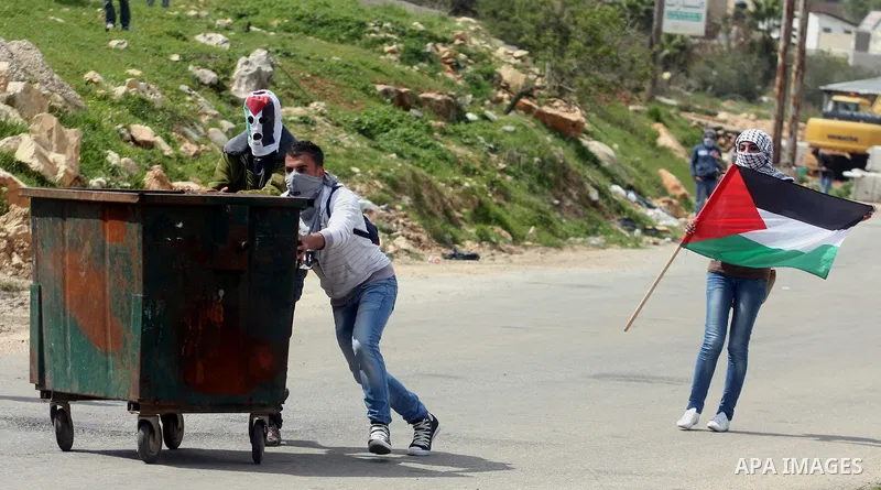 Palestinians clash with Israeli troops, not seen, during a protest outside the Ofer military prison, near the West Bank city of Ramallah Monday, March 26, 2012. Clashes erupted during a demonstration calling to release p...