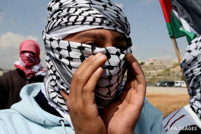 Masked Palestinian demonstrators call for the release of prisoners during a protest outside the Ofer military prison, near the West Bank city of Ramallah Monday, March 26, 2012. Clashes erupted during a demonstration cal...
