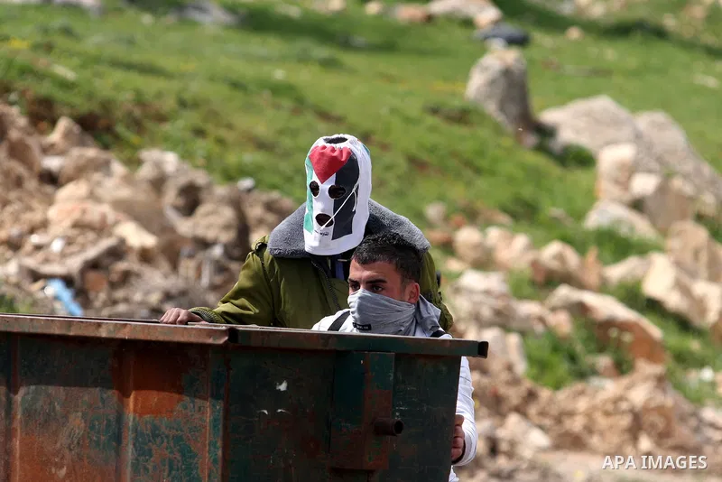 Palestinians clash with Israeli troops, not seen, during a protest outside the Ofer military prison, near the West Bank city of Ramallah Monday, March 26, 2012. Clashes erupted during a demonstration calling to release p...