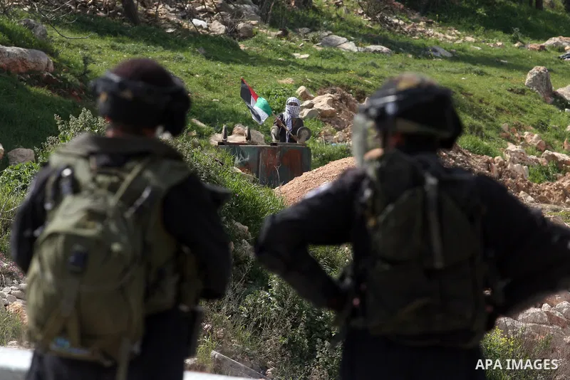 Palestinians clash with Israeli troops, not seen, during a protest outside the Ofer military prison, near the West Bank city of Ramallah Monday, March 26, 2012. Clashes erupted during a demonstration calling to release p...